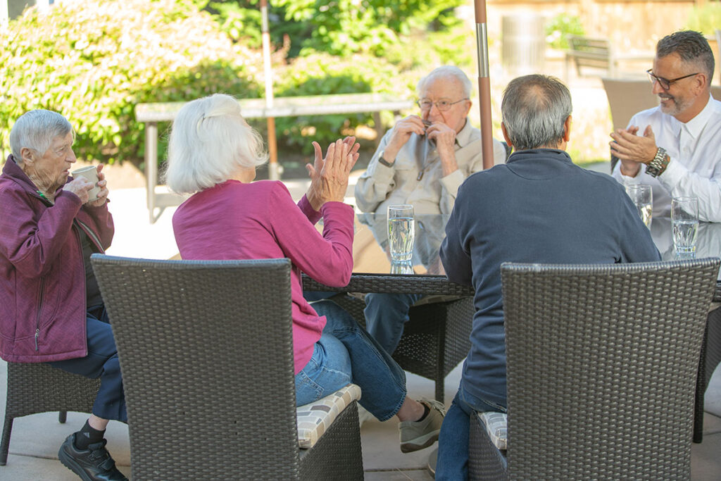 Resident playing the harmonica for other residents