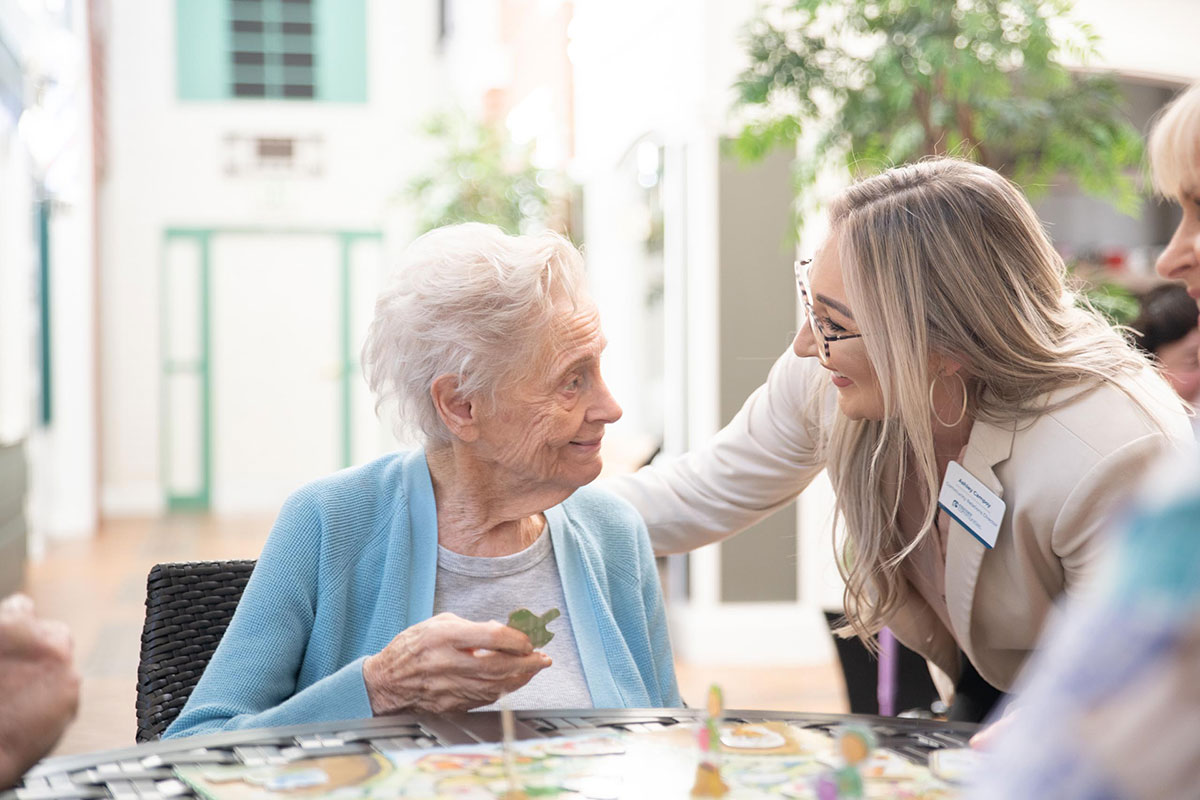 Staff member speaking to a resident who is completing a puzzle