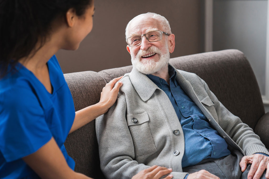 nurse sitting with man on couch