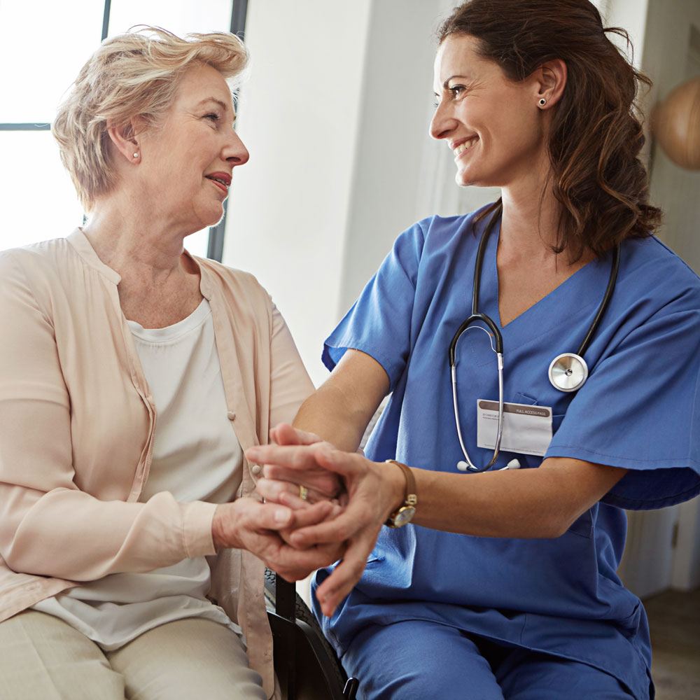 nurse helping woman in wheelchair