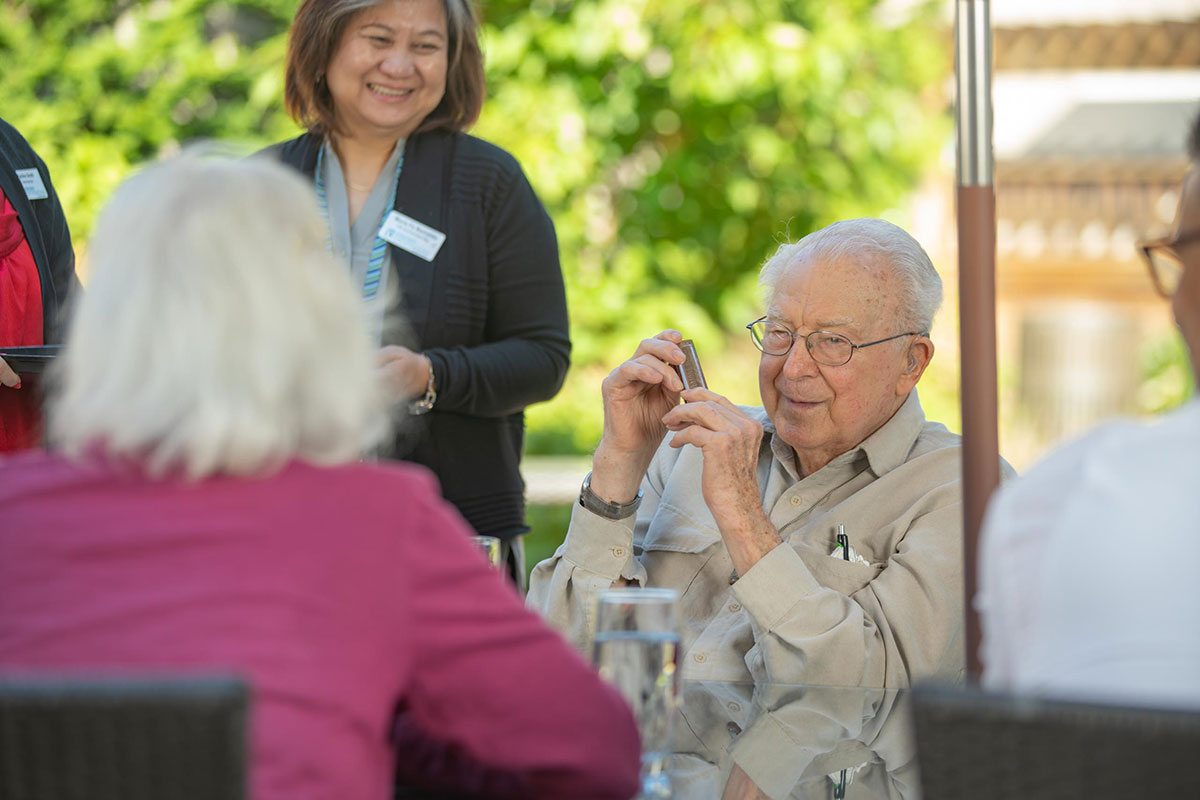 Resident playing the harmonica for other residents