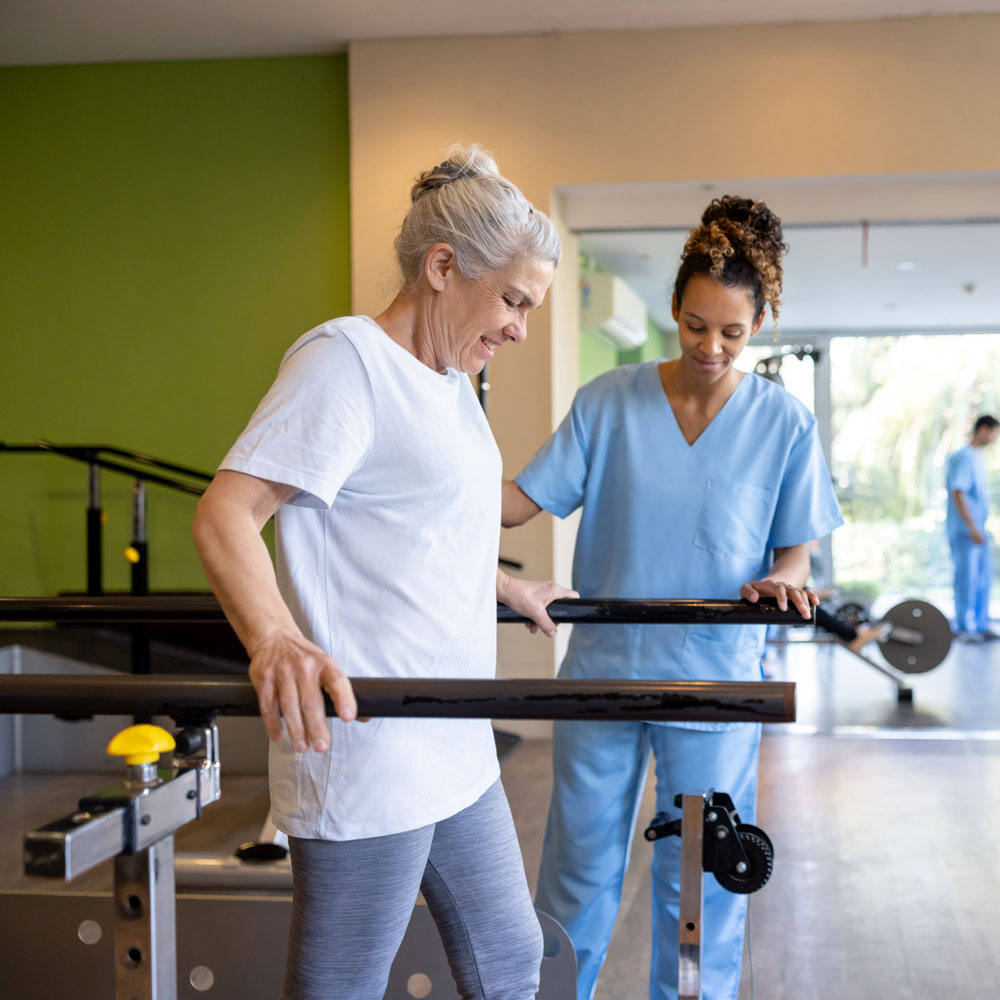 nurse assisting woman walk