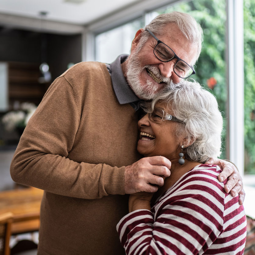 elderly couple hugging