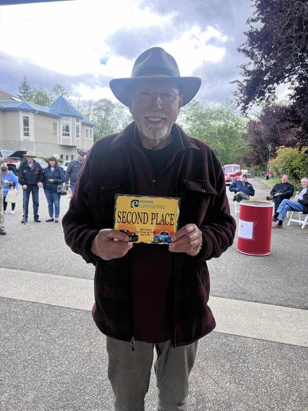 man holding 2nd place sign at outdoor event